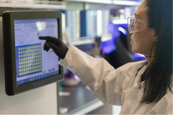 Woman in Lab pointing at Diagnostic Screen